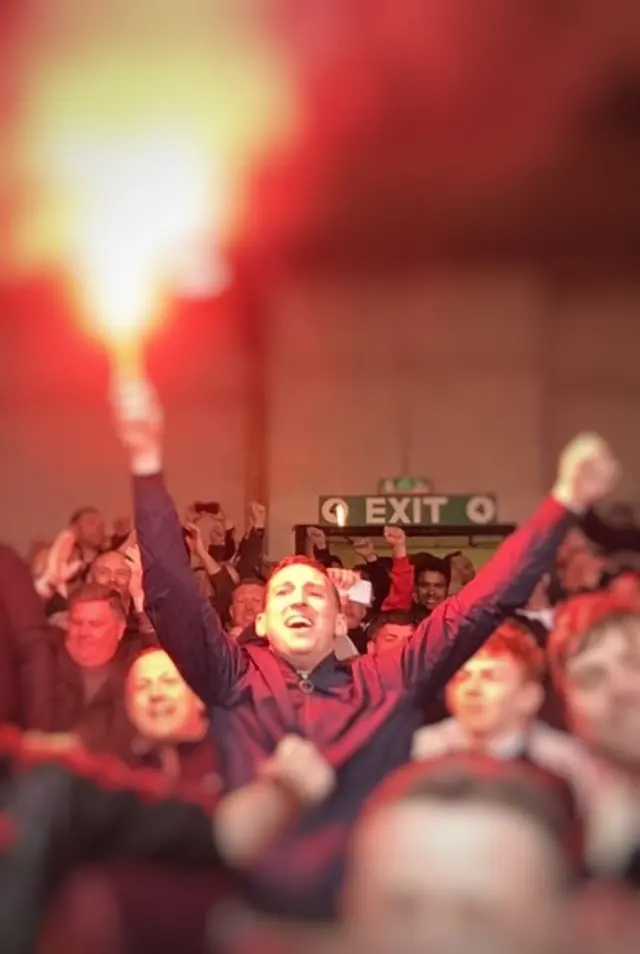 Fan holding flare in crowd at Port Vale