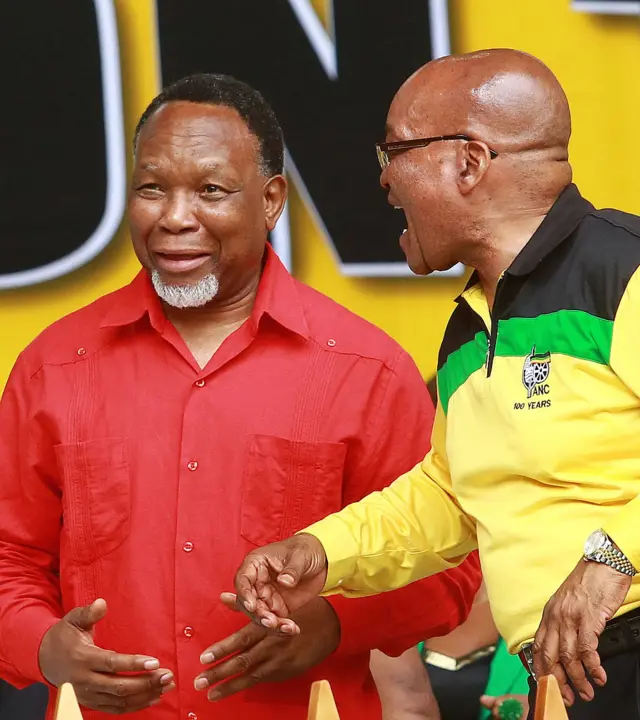 South Africa's President and African National Congress (ANC) leader Jacob Zuma (R) jokes with former ANC Deputy President Kgale Motlanthe during a event commemorating the 101st birthday of the ANC party in Durban on January 12, 2013.