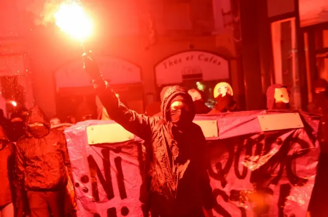 Left-wing demonstrators march in Nantes, western France, waving banners that translate as "not a banker nor a racist", 23 April 2017