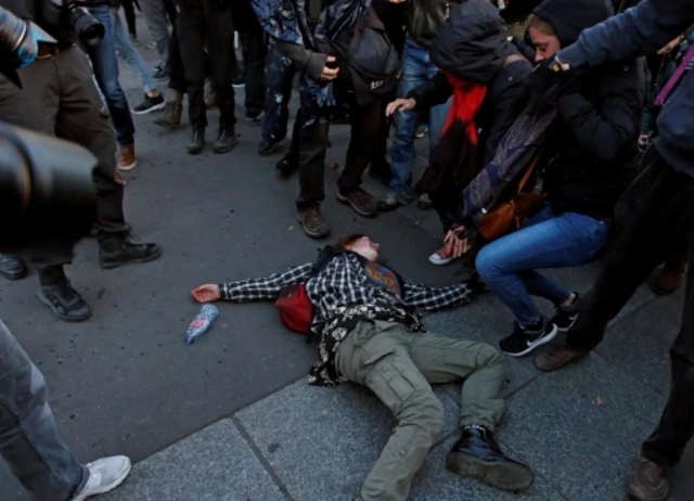 A demonstrator lays on the ground during clashes with police in Paris, 23 April 2017