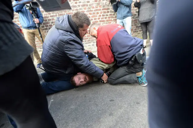 Photographer Jacob Khrist is detained during a protest by members of feminist activist group Femen at a polling station in Henin-Beaumont, north-western France