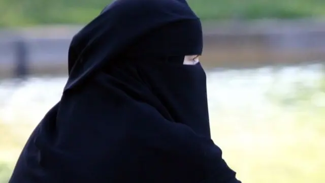 Muslim woman wears a full-face veil in Regent's Park, London