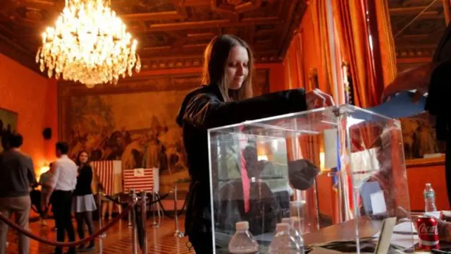 Some overseas voters - including this woman at the French consulate in New York - have already cast their ballots