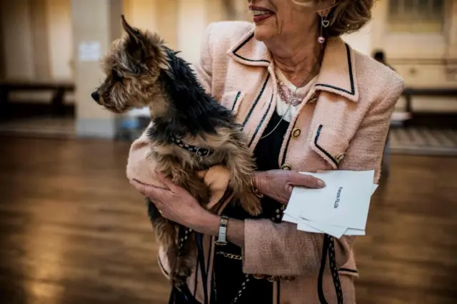 A woman carries her dog as she cast her vote at a polling booth in Lyon