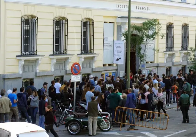 French nationals queue outside the French Institute and French general consulate in Madrid