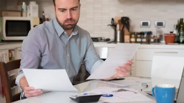 man reading bills