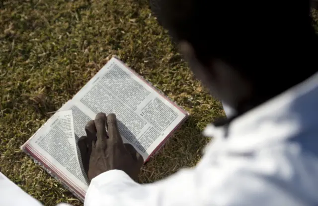 worshipper reads the bible in the Hillbrow neighbourhood overlooking downtown Johannesburg on June 30, 2013.