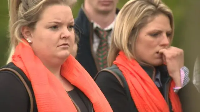 Mourners with orange scarves