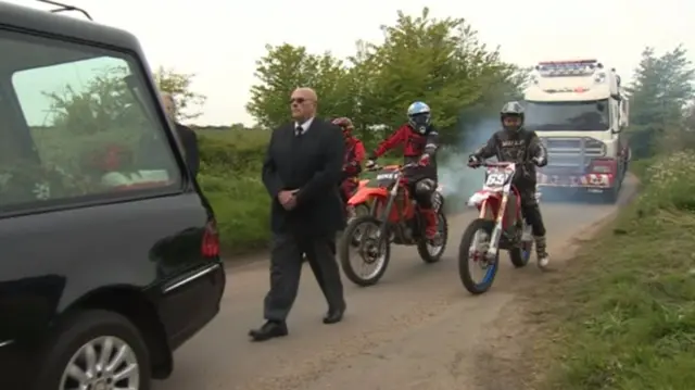 Three motocross bikes in the funeral cortege, ahead of the lorry