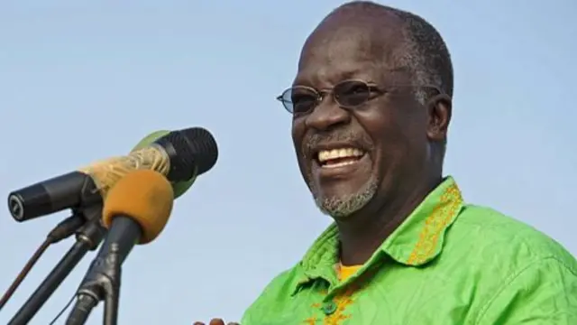 Presidential candidate John Magufuli laughs as microphones are set up during a ruling Chama Cha Mapinduzi (CCM) rally in Dar es Salaam