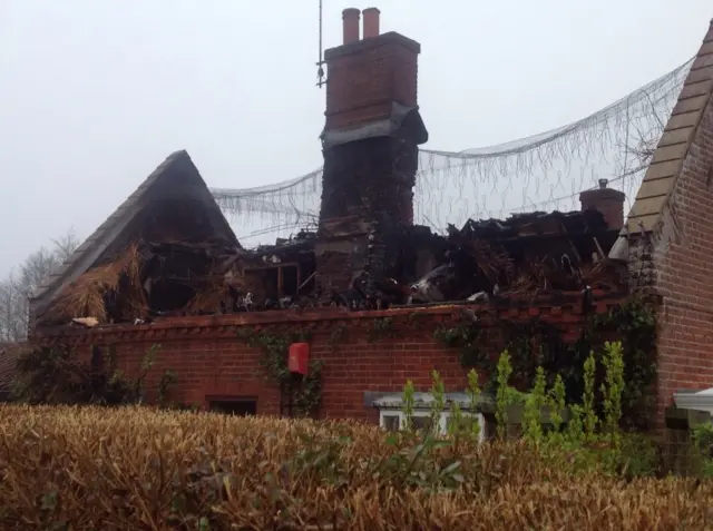 The exposed roof of the red brick property