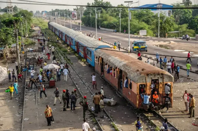 
          People walk near a train in Kinshasa on April 3, 2017 during a general strike called by the opposition
        