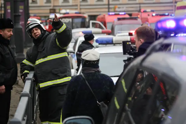 
          Emergency services direct pedestrians outside Sennaya Ploshchad metro station following explosions in St. Petersburg
        