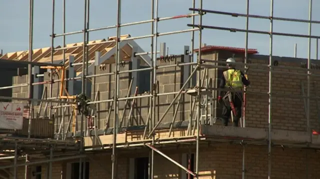 Housing construction, with builder on scaffolding