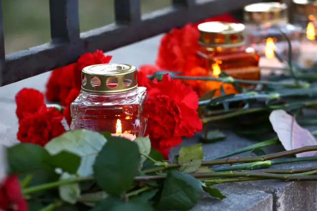 
          A candle and flowers are seen to commemorate victims of a blast in Russian St.Petersburg metro, at the Russian embassy in Minsk, Belarus
        