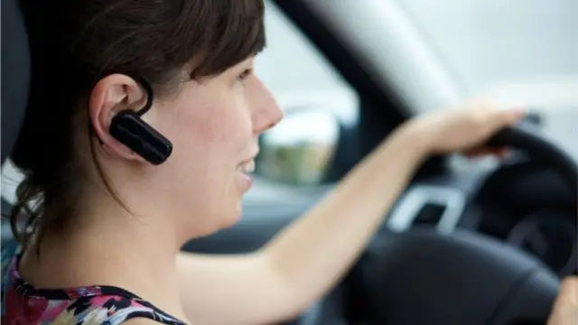 A stock photo of a woman using a hands-free kits