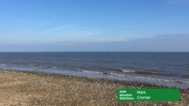 Blue sky over Cromer beach with gentle waves