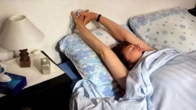 Person stretching in bed