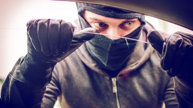 Car thief looking through the open window