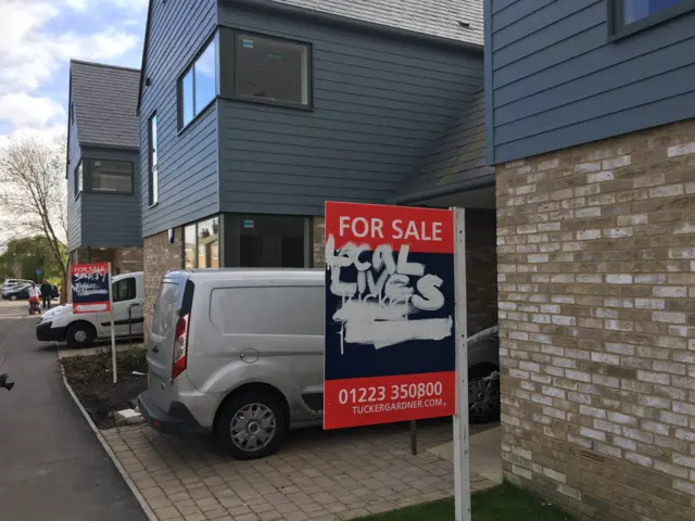 Graffiti on house for sale sign