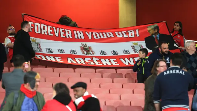 
          Arsenal fans rolls up a banner showing respect to Manager Arsene Wenger
        