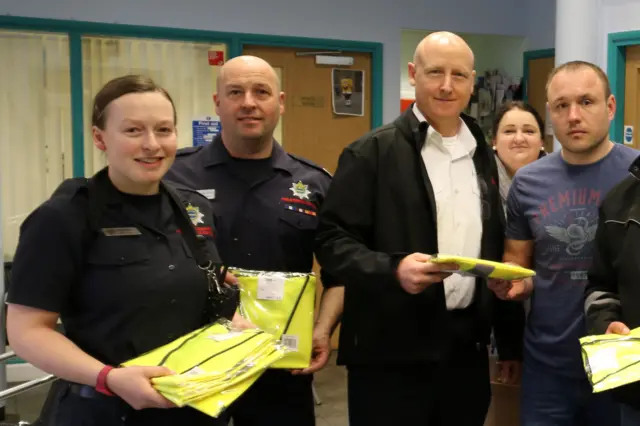 Firefighters handing out high visibility jackets