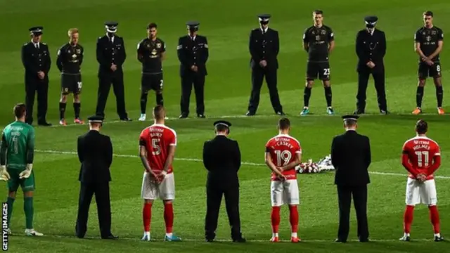 Players and police officers paying tribute at The Valley