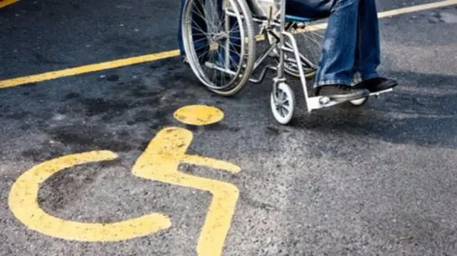 Wheelchair user on disabled parking space