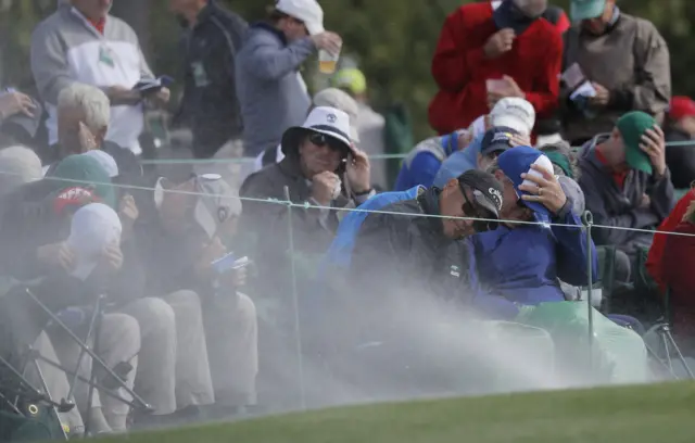 
          Sand from a bunker on the 18th green blows into the faces of patrons
        