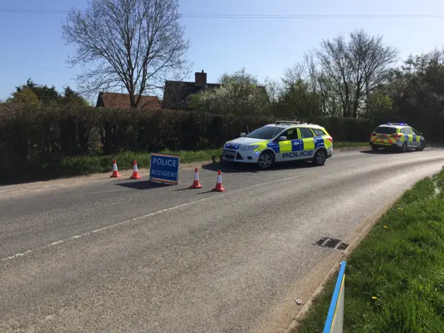 Two police vehicles and sign warning of accident