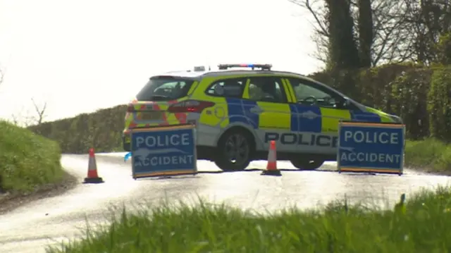 Side view of police vehicle and accident signs