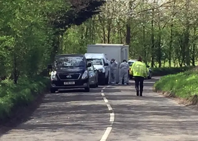 Forensics officers in white suits