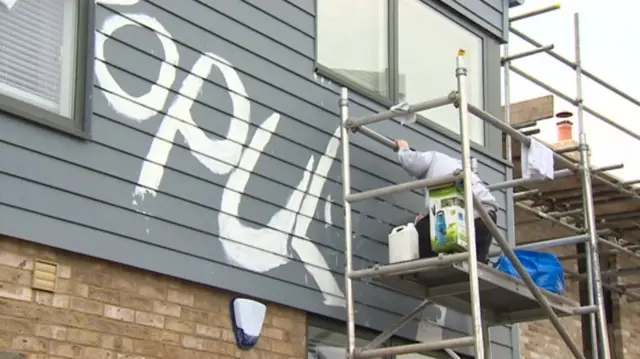 Graffiti being cleaned off houses