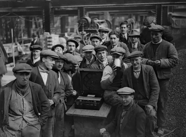 Workmen listen to the Grand National