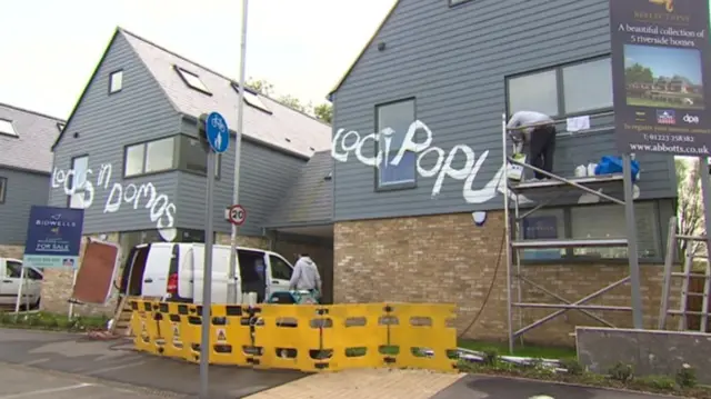 Graffiti being cleaned off houses