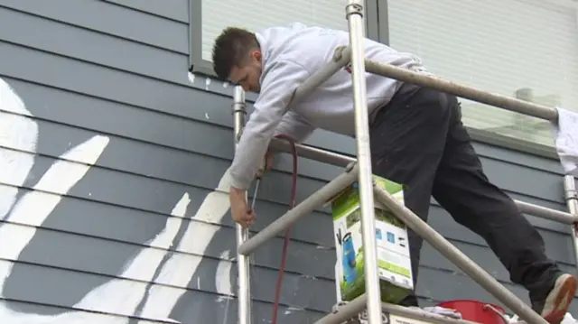 Graffiti being cleaned off houses