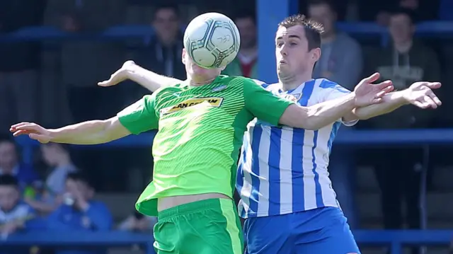 
          Cliftonville's Aaron Haire in action against Coleraine's David Ogilby
        