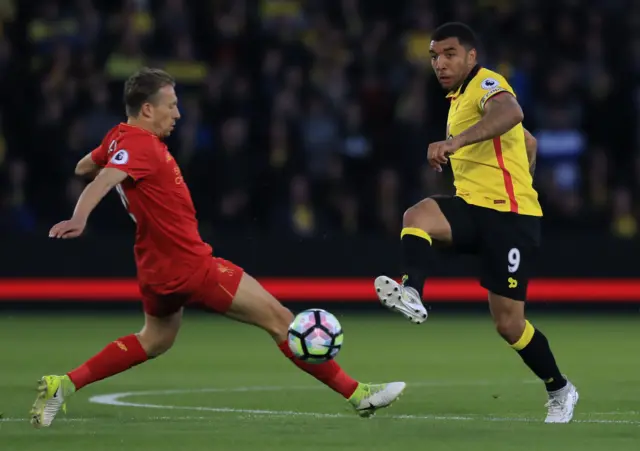 Troy Deeney of Watford passes under pressure from Lucas Leiva