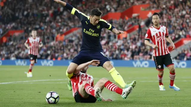 Arsenal's Mesut Ozil is tackled