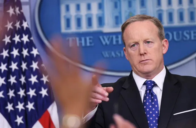 Reporters raise their hands with questions for White House Press Secretary Sean Spicer speaks during the daily briefing