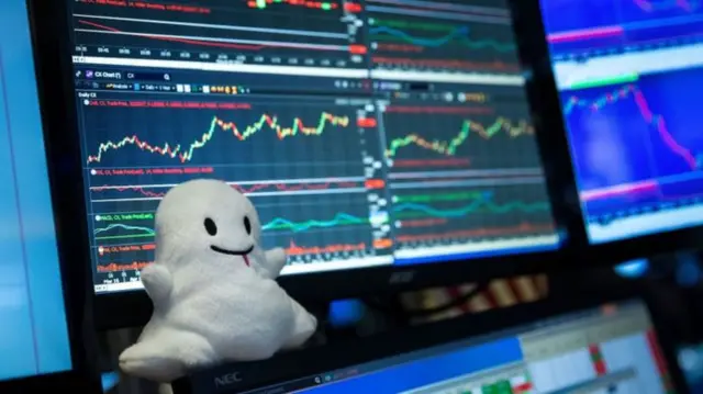 Snap logo in form of soft toy in front of computer screen