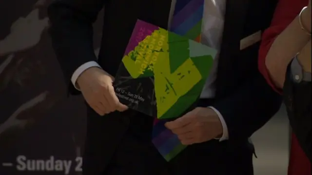 Close up of hands holding a Norfolk and Norwich Festival brochure