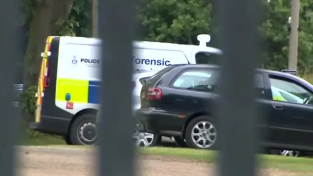 Police forensic vehicles at the boat yard