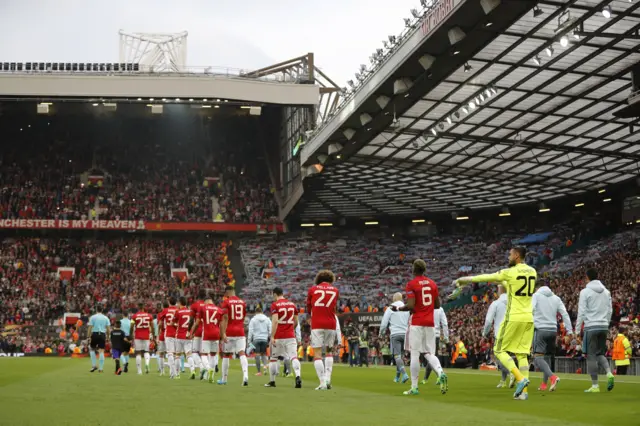 Manchester United players walk onto the field