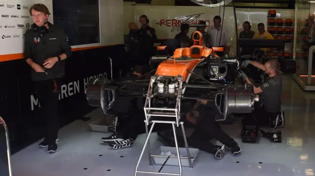 Mechanics work on Fernando Alonso's car