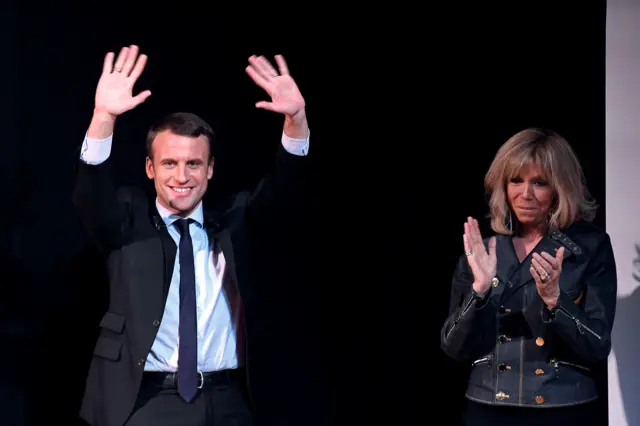 French presidential election candidate for the En Marche movement Emmanuel Macron (L) and his wife Brigitte Trogneux (R) attending an event on 8 March 2017