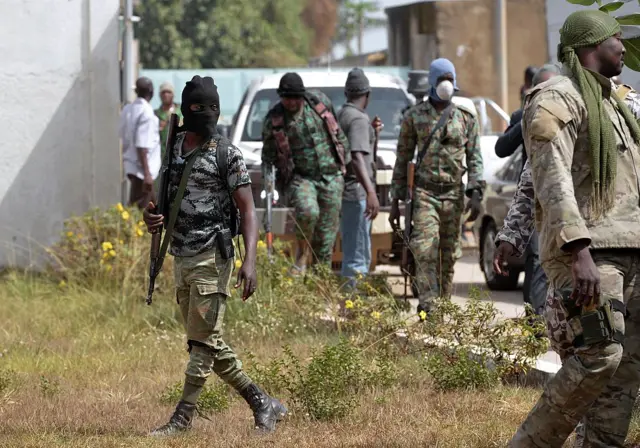 Mutineer soldiers stand in front of the deputy-prefect (sous-prefet) residence upon arrival of the Ivorian Defence minister