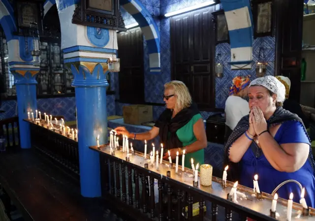 People lighting candle