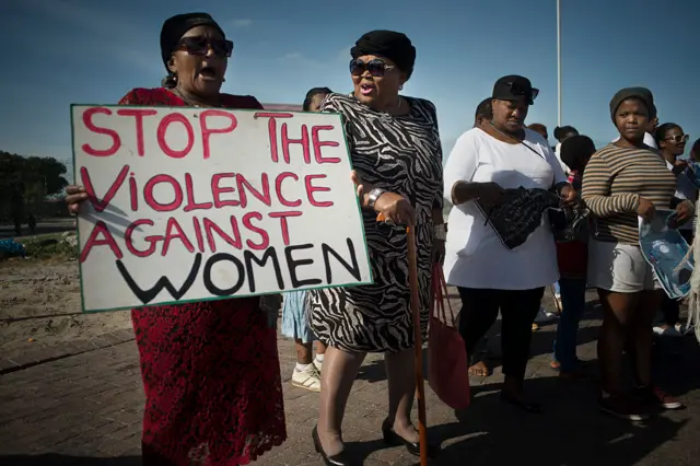 Women hold signs during a protest against ongoing violence against women, in Gugulethu, on May 21, 2016