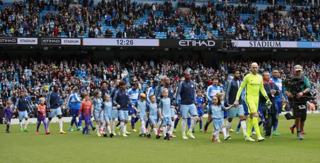 The teams come out onto the pitch